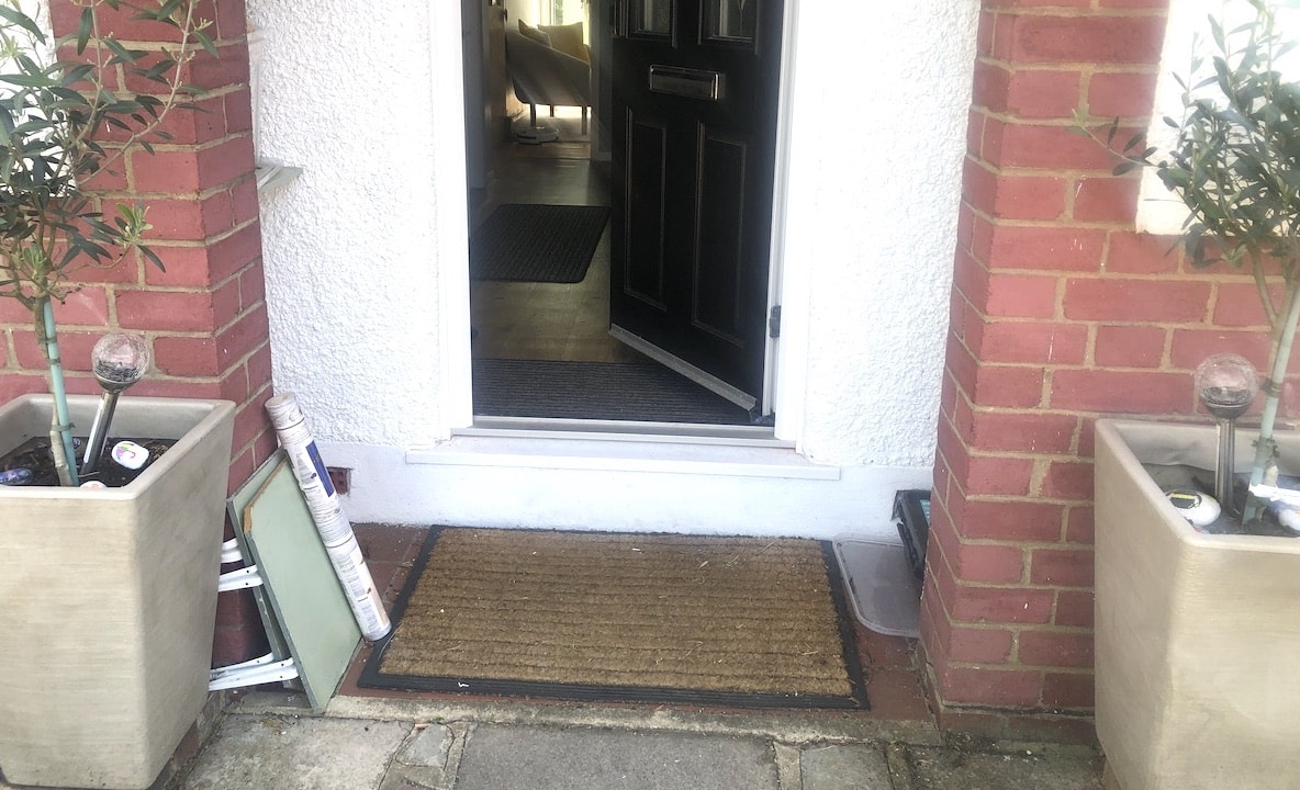 The old porch - terracotta tiles and a drabby doormat!